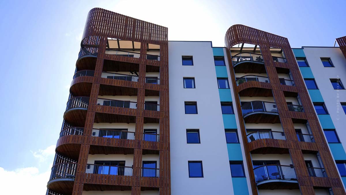 Modernes Mehrfamilienhaus mit Balkon und Fenster und weißer, blauer und brauner Fassade